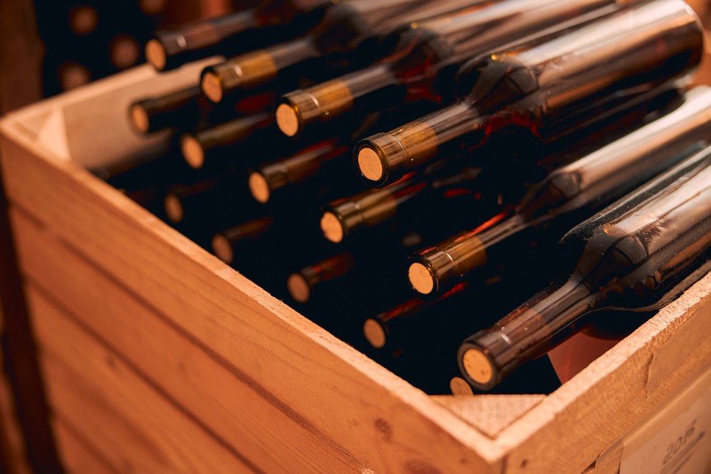 Coffret en bois avec bouteilles en verre de boissons alcoolisées dans une cave à vin