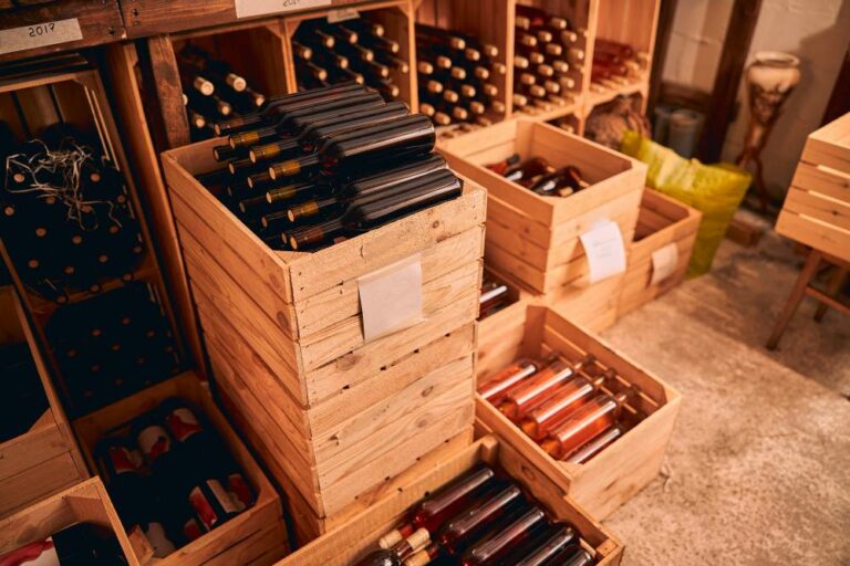Cave à vin avec bouteilles en verre de boisson alcoolisée dans des caisses en bois