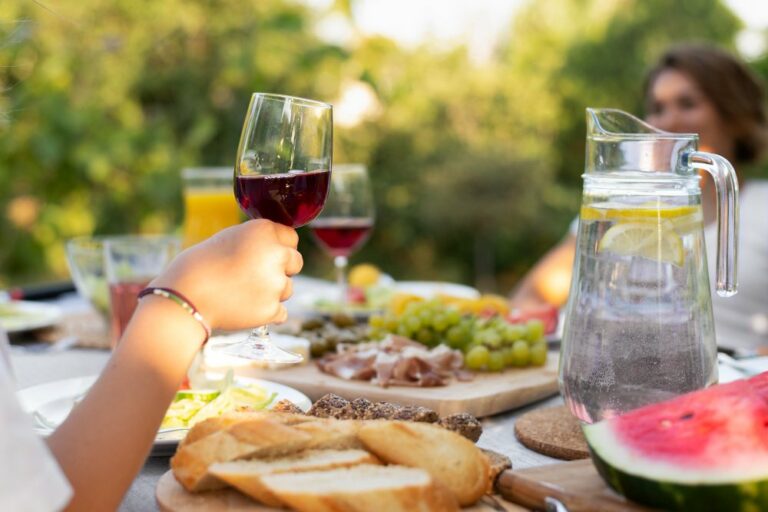 Repas printanier et dame qui tient un verre de vin