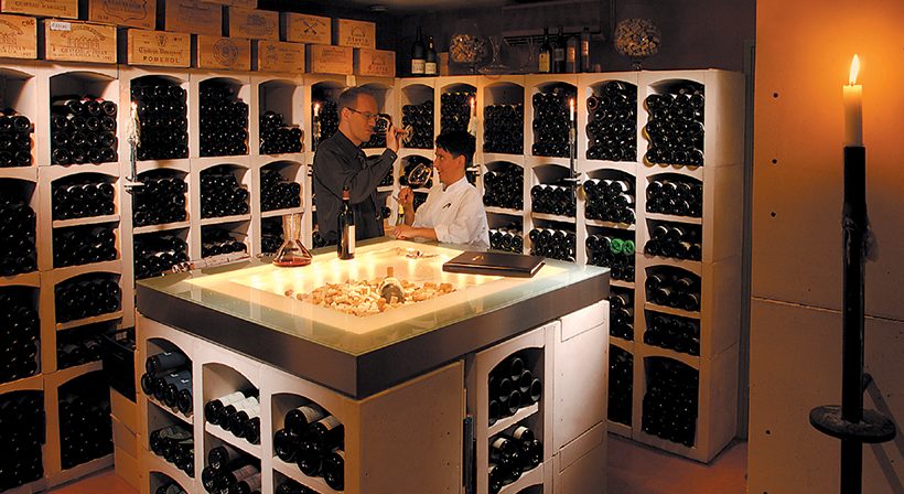 deux hommes goûtent le vin dans une cave